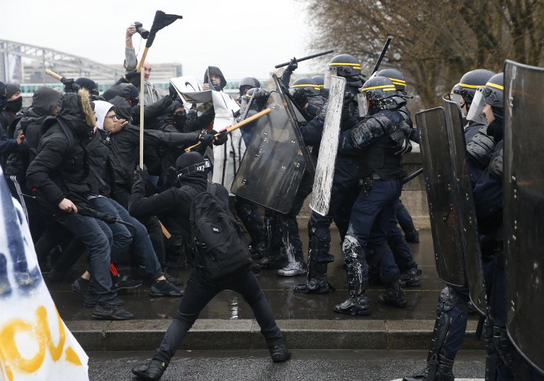 French riot police clash with union members and students demonstrating against labour law reforms gathered close to the Gare de Lyon train station in the French capital Paris on March 31, 2016. France faced fresh protests over labour reforms just a day after the beleaguered government of President Francois Hollande was forced into an embarrassing U-turn over constitutional changes. AFP PHOTO / THOMAS SAMSON / AFP / THOMAS SAMSON